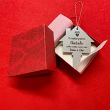 Pallina di Natale “Nuova Casa” in plexiglass argento specchiato con incisione laser, presentata in scatola regalo rossa aperta.